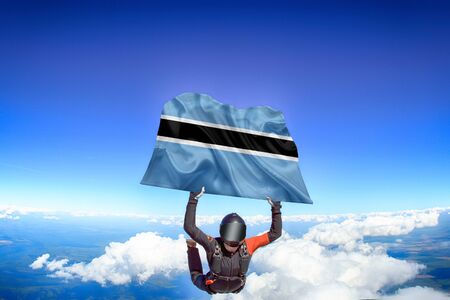 Botswana extreme. Flag in skydiving. People in free fall grab flag of Botswana. Patriotism, men and...
