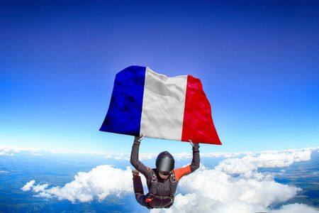 France extreme. Flag in skydiving. People in free fall grab flag of France. Patriotism, men and flag.の写真素材