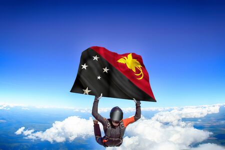 Papua New Guinea extreme. Flag in skydiving. People in free fall grab flag of Papua New Guinea. Patriotism, men and flag.の写真素材