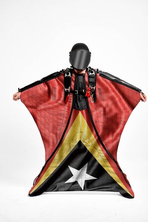 East Timor extreme. Flag in skydiving. People in free fall grab flag of East Timor. Patriotism, men and flag.の写真素材