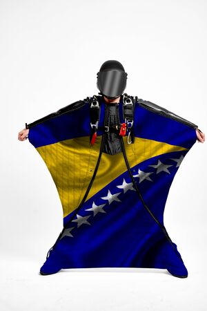 Bosnia and Herzegovina extreme. Flag in skydiving. People in free fall grab flag of Bosnia and Herzegovina. Patriotism, men and flag.の写真素材