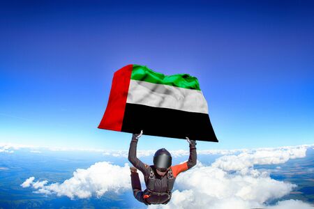 Kuwait extreme. Flag in skydiving. People in free fall grab flag of Kuwait. Patriotism, men and flag.の写真素材
