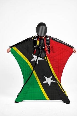 Saint Kids and Nevis extreme. Flag in skydiving. People in free fall grab flag of Saint Kids and Nevis. Patriotism, men and flag.の写真素材