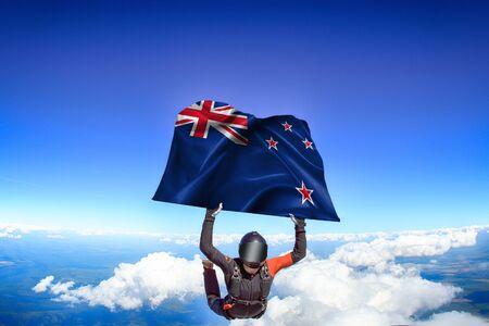 New Zealand extreme. Flag in skydiving. People in free fall grab flag of New Zealand. Patriotism, men and flag.の写真素材