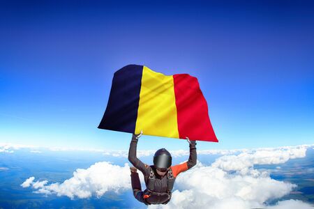 Chad extreme. Flag in skydiving. People in free fall grab flag of Chad. Patriotism, men and flag.の写真素材