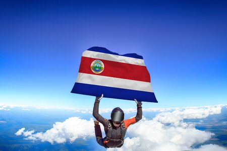 Costa Rica extreme. Flag in skydiving. People in free fall grab flag of Costa Rica. Patriotism, men and flag.の写真素材