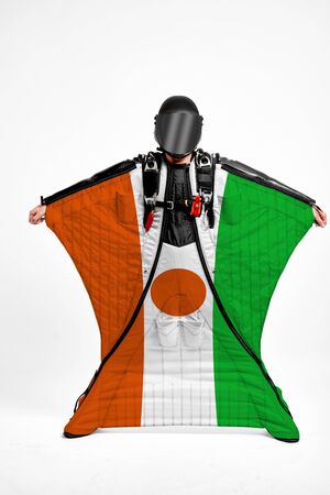 Niger extreme. Flag in skydiving. People in free fall grab flag of Niger. Patriotism, men and flag.の写真素材