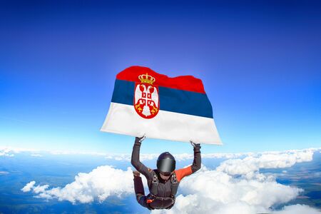 Serbia extreme. Flag in skydiving. People in free fall grab flag of Serbia. Patriotism, men and flag.の写真素材