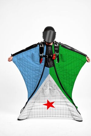 Djibouti extreme. Flag in skydiving. People in free fall grab flag of Djibouti. Patriotism, men and flag.の写真素材