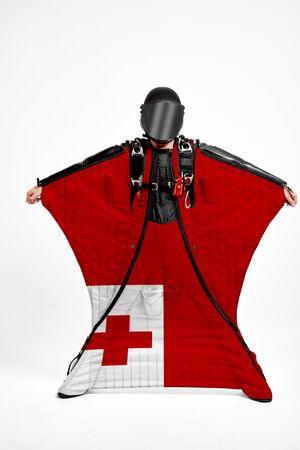 Tongo extreme. Flag in skydiving. People in free fall grab flag of Tongo. Patriotism, men and flag.の写真素材