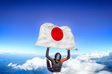 Japan extreme. Flag in skydiving. People in free fall grab flag of Japan. Patriotism, men and flag.の写真素材