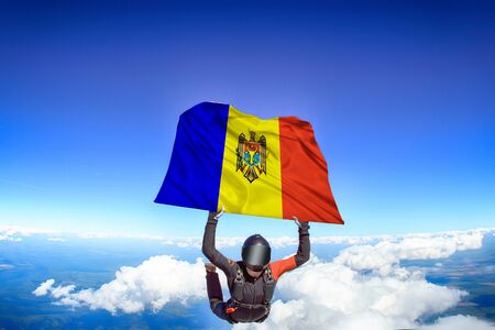 Moldova extreme. Flag in skydiving. People in free fall grab flag of Moldova. Patriotism, men and flag.の写真素材