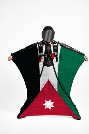 Jordan extreme. Flag in skydiving. People in free fall grab flag of Jordan. Patriotism, men and flag.の写真素材