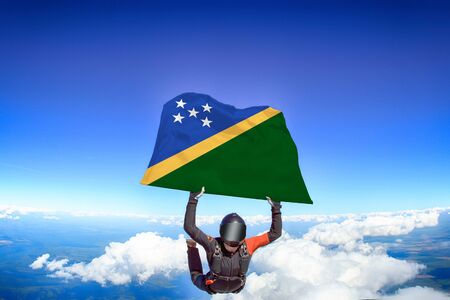 Solomon islands extreme. Flag in skydiving. People in free fall grab flag of Solomon islands. Patriotism, men and flag.の写真素材
