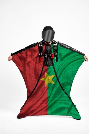 Burkina Faso extreme. Flag in skydiving. People in free fall grab flag of Burkina Faso. Patriotism, men and flag.の写真素材