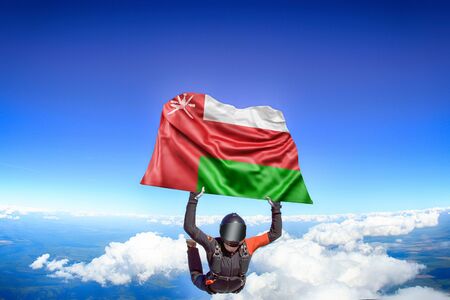 Oman extreme. Flag in skydiving. People in free fall grab flag of Oman. Patriotism, men and flag.の写真素材
