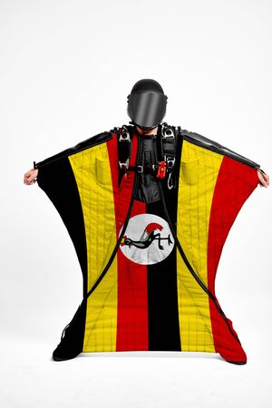 Uganda extreme. Flag in skydiving. People in free fall grab flag of Uganda. Patriotism, men and flag.の写真素材