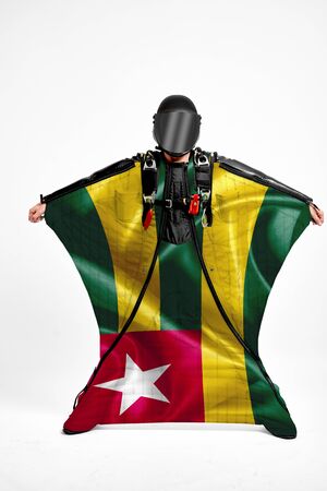 Togo extreme. Flag in skydiving. People in free fall grab flag of Togo. Patriotism, men and flag.の写真素材
