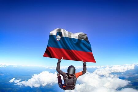 Slovakia extreme. Flag in skydiving. People in free fall grab flag of Slovakia. Patriotism, men and flag.の写真素材