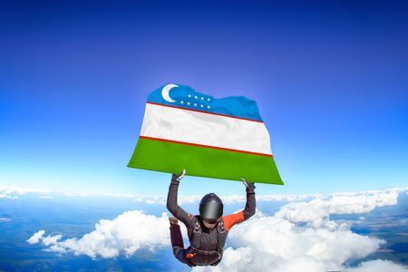 Uzbekistan extreme. Flag in skydiving. People in free fall grab flag of Uzbekistan. Patriotism, men and flag.の写真素材