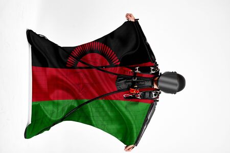 Malawi flag. Men in wing suit templet. People in free fall grab flag of Malawi. Patriotism, men and flag.の写真素材