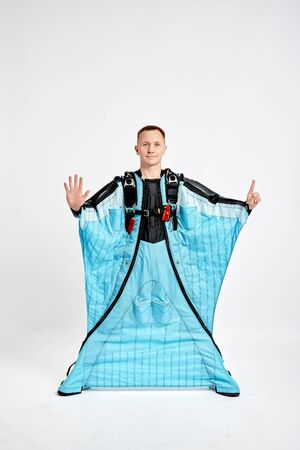 Six fingers. Men in wing suit show six fingers. Skydiving men in parashute. Simulator of free fall.の写真素材