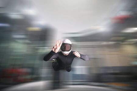 Three finfers. Men in parachute shows three fingers. Gesture by fingers. Skydiving sport.の写真素材