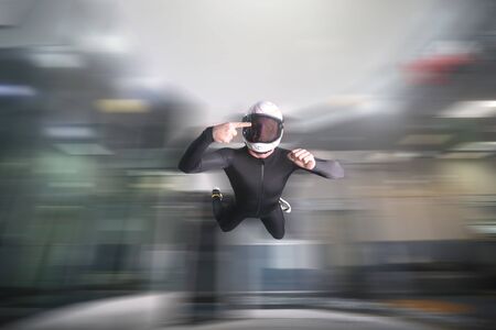 One finger. Fly men show one finger. Sky diver in black suit. Teampleat skydiver.の写真素材
