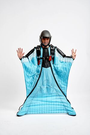 Eight fingers. Men in wing suit show eight fingers. Skydiving men in parashute. Simulator of free fall.の写真素材