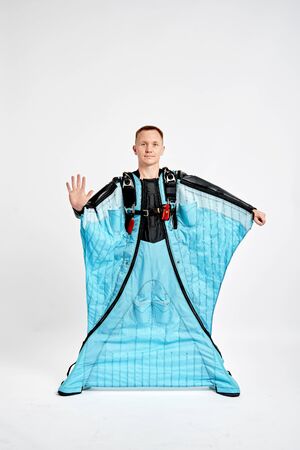 Five fingers. Men in wing suit show fivefingers. Skydiving men in parashute. Simulator of free fall.の写真素材