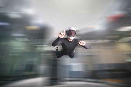One finger. Fly men show one finger. Sky diver in black suit. Teampleat skydiver.の写真素材