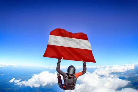 Austria extreme. Flag in skydiving. People in free fall grab flag of Austria. Patriotism, men and flag.の写真素材
