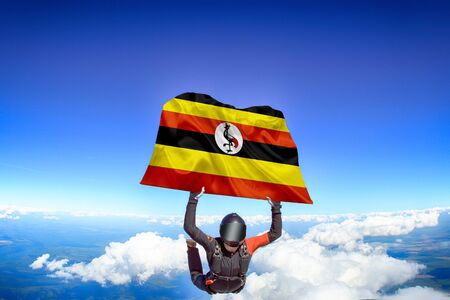 Uganda extreme. Flag in skydiving. People in free fall grab flag of Uganda. Patriotism, men and flag.の写真素材