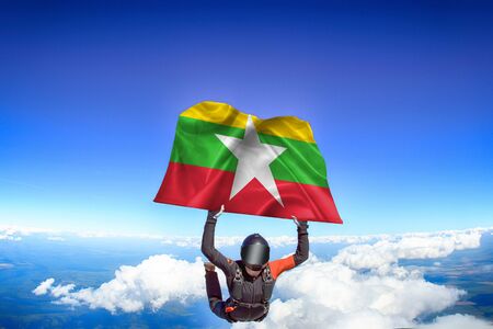 Myanmar extreme. Flag in skydiving. People in free fall grab flag of Myanmar. Patriotism, men and flag.の写真素材