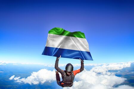 Sierra Leone extreme. Flag in skydiving. People in free fall grab flag of Sierra Leone. Patriotism, men and flag.の写真素材