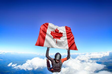 Canada extreme. Flag in skydiving. People in free fall grab flag of Canada. Patriotism, men and flag.の写真素材