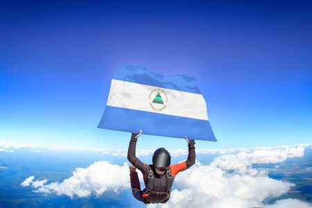 Nicaragua extreme. Flag in skydiving. People in free fall grab flag of Nicaragua. Patriotism, men and flag.の写真素材