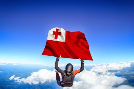 Tongo extreme. Flag in skydiving. People in free fall grab flag of Tongo. Patriotism, men and flag.の写真素材