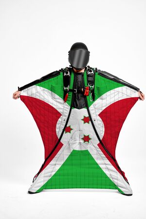 Burundi flag travel. Simulator of free fall. Men in wing suit.の写真素材