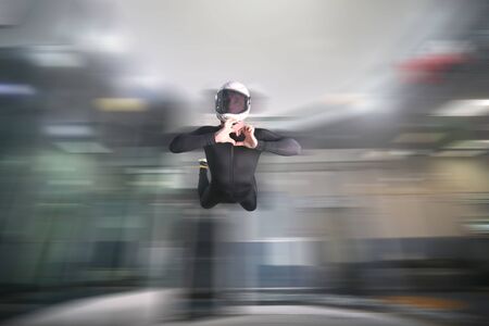 Heart with hands. Men in parachute shows heart with hands. Gesture by fingers. Skydiving sport.の写真素材
