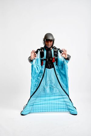 Ok. Men in wing suit shows gesture ok with fingers. Skydiving men in parashute. Simulator of free fall.の写真素材