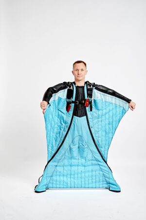 Point a finger. Men in wing suit pointes a finger. Skydiving men in parashute. Simulator of free fall.の写真素材