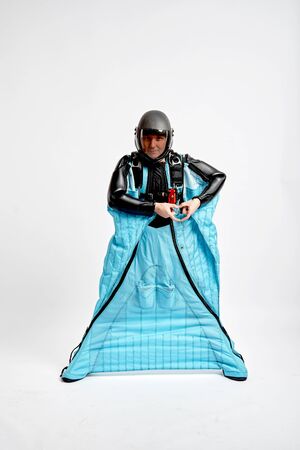 Heart by hands. Men in wing suit shows heart by hands. Skydiving men in parashute. Simulator of free fall.の写真素材