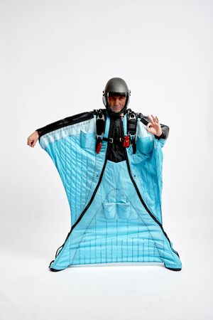 Ok. Men in wing suit shows gesture ok with fingers. Skydiving men in parashute. Simulator of free fall.の写真素材