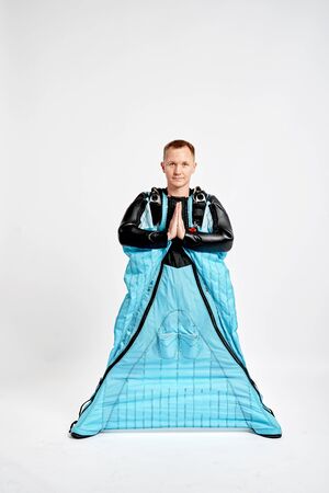 Meditation. Men in wing suit shows meditation gesture. Skydiving men in parashute. Simulator of free fall.の写真素材