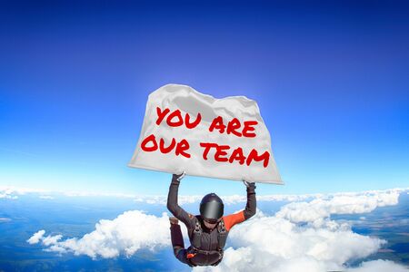 You are our team. Men in parachute equipment. Skydiving sport. Extreme hobby as a way of life. Parachuting. Men in free fall.の写真素材