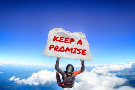 Keep a promise. Men in parachute equipment. Skydiving sport. Extreme hobby as a way of life. Parachuting. Men in free fall.の写真素材