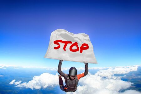 Stop. Men in parachute equipment. Skydiving sport. Extreme hobby as a way of life. Parachuting. Men in free fall.の写真素材