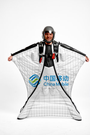 China mobile logo. Bird men. Men in wing suit equipment.Demonstration of popular brands. Simulator of free fall.のeditorial素材