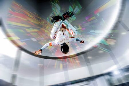 Adrenaline. Extreme sky for free people. No rules in open air. Parachutist in white suit is in free fall. Skydiving is a sport of the future.の写真素材